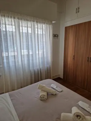 a bedroom with towels on a bed with a window at EstellApartments in Athens