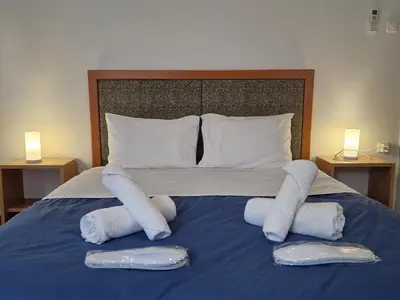 a bed with two pillows and towels on it at EstellApartments in Athens