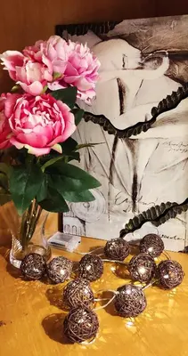 a table with a vase with pink roses and silver balls at Secret Garden Home Lagonissi Attiki in Foinikiá