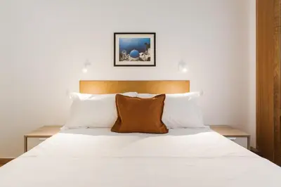 a bedroom with a bed with white sheets and pillows at Neat Kolonaki Apartment, Athens City Centre - NV8 in Athens
