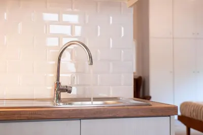 a kitchen counter with a sink in a kitchen at Serenity - Brand New Apt Near Athens Int Arpt in Spáta