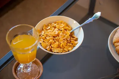 a bowl of cereal and a glass of orange juice at Serenity - Brand New Apt Near Athens Int Arpt in Spáta