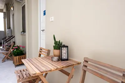 a wooden table in a room with two benches at Serenity - Brand New Apt Near Athens Int Arpt in Spáta
