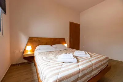 a bedroom with a bed with two towels on it at Serenity - Brand New Apt Near Athens Int Arpt in Spáta