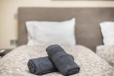 a rolled up towel sitting on top of a bed at Panathenaic Stadium By Greece Apartments in Athens