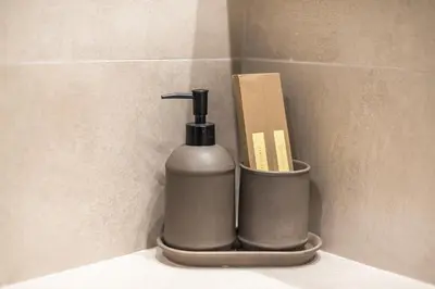 a soap dispenser sitting on a shelf in a bathroom at Panathenaic Stadium By Greece Apartments in Athens