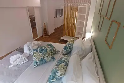a bed with pillows on it in a room at The Owl nest Modern and Cozy place in the Historical Center in Athens