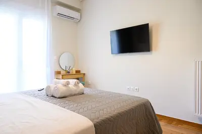 a bedroom with a bed and a flat screen tv at Athens city spot in Athens