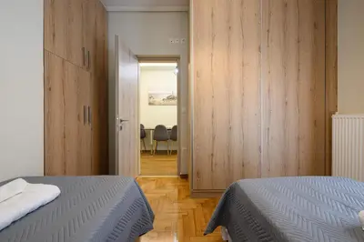 a bedroom with two beds and a dining room at Athens city spot in Athens