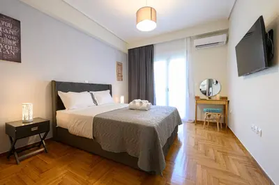 a bedroom with a bed and a television in it at Athens city spot in Athens