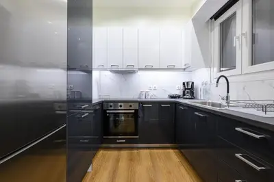 a kitchen with black and white cabinets and a sink at Athens city spot in Athens