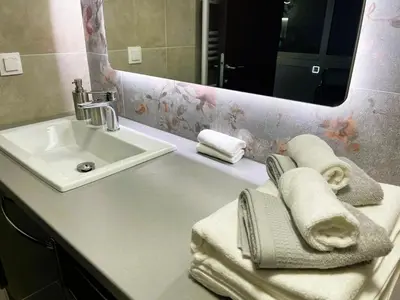 a bathroom with a sink and a mirror and towels at Apartment 55 in Athens