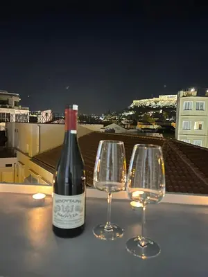 a bottle of wine and two wine glasses on a table at Apartment 55 in Athens