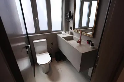 a bathroom with a toilet and a sink and windows at IPELHOME-Avissinias Boutique Apartments in Athens
