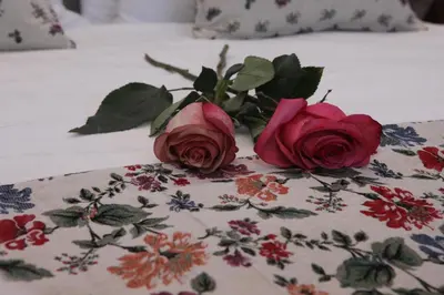 two roses sitting on top of a bed at IPELHOME-Avissinias Boutique Apartments in Athens