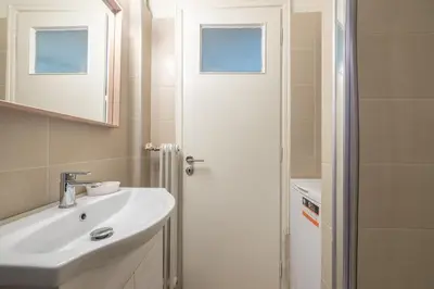 a bathroom with a white sink and a shower at Athenean Classic Apartment at Acropolis Museum & Metro in Athens