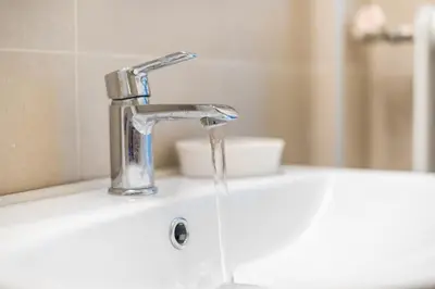 a sink with water running from a faucet at Athenean Classic Apartment at Acropolis Museum & Metro in Athens