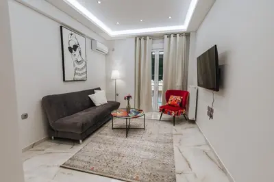 a living room with a couch and a red chair at Sweet Dreams 2 Bedroom VIPGreece in Athens