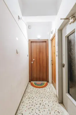 a hallway with a wooden door and a rug on the floor at Sweet Dreams 2 Bedroom VIPGreece in Athens
