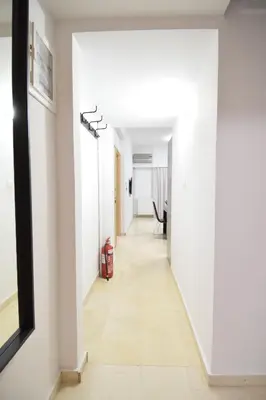 a hallway with white walls and a white floor at acropolis super cosy apartment in Athens