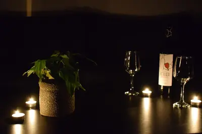 a table with a plant and candles and wine glasses at acropolis super cosy apartment in Athens