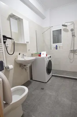 a bathroom with a washing machine and a sink at acropolis super cosy apartment in Athens