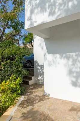 a car parked on the stairs of a white house at Porto sea view house - 15min from Athens airport - AC - WIFI - PARKING in Porto Rafti