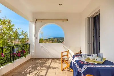 a room with a table and a balcony with a view at Porto sea view house - 15min from Athens airport - AC - WIFI - PARKING in Porto Rafti