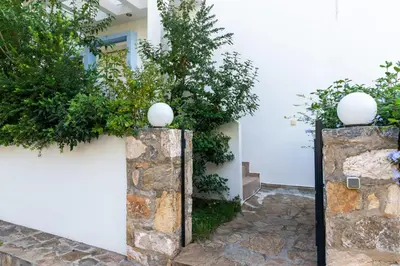 two stone pillars with plants on a white wall at Porto sea view house - 15min from Athens airport - AC - WIFI - PARKING in Porto Rafti