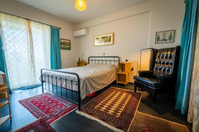 a bedroom with a bed and a chair at Spacious apartment in Kavouri in Athens