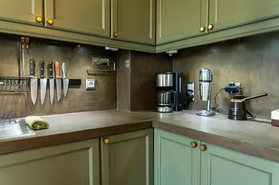 a kitchen with green cabinets and a counter top at Spacious apartment in Kavouri in Athens