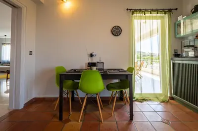 a dining room with a table and green chairs at Spacious apartment in Kavouri in Athens