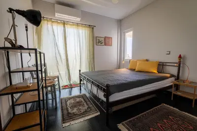 a bedroom with a bed and a window at Spacious apartment in Kavouri in Athens