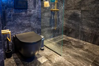 a bathroom with a toilet and a glass shower at Spacious apartment in Kavouri in Athens