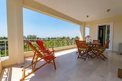a patio with rocking chairs and a table on a balcony at Spacious apartment in Kavouri in Athens