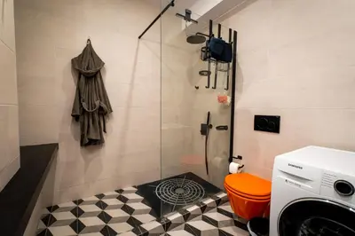 a bathroom with a shower and a washing machine at Spacious apartment in Kavouri in Athens
