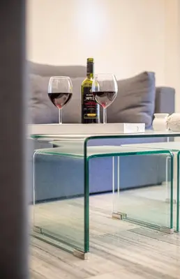 two glasses of wine sitting on a glass table at Hermes Apartments, 2 bedrooms, great facilities! in Athens