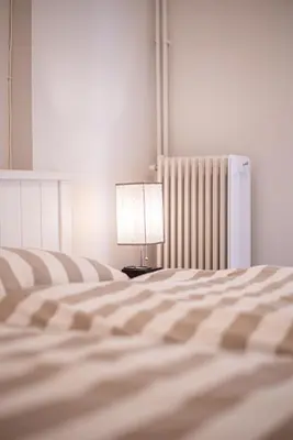 a bedroom with a bed with a lamp and a radiator at Hermes Apartments, 2 bedrooms, great facilities! in Athens