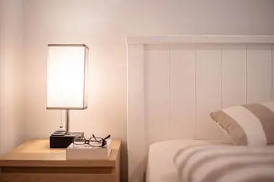 a lamp on a night stand next to a bed at Hermes Apartments, 2 bedrooms, great facilities! in Athens