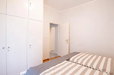 a white bedroom with a bed and a mirror at Hermes Apartments, 2 bedrooms, great facilities! in Athens
