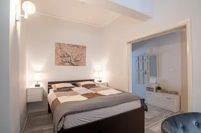 a bedroom with a large bed and a blue chair at Hermes Apartments, 2 bedrooms, great facilities! in Athens