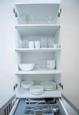 a white pantry with plates and bowls and utensils at Hermes Apartments, 2 bedrooms, great facilities! in Athens