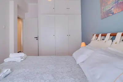 a white bedroom with a bed with white pillows at Lovingly restored apartment Galatsi in Athens