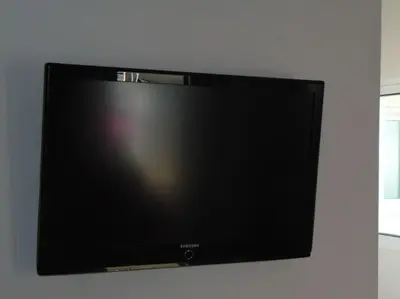 a flat screen tv hanging on a wall at Lovingly restored apartment Galatsi in Athens