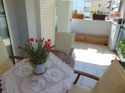 a table with a vase of flowers on a balcony at Lovingly restored apartment Galatsi in Athens