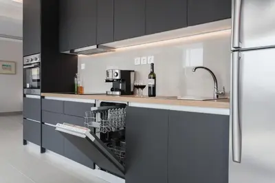 a kitchen with black cabinets and a bottle of wine at Loft in Psirri by Liberty's Canvas in Athens