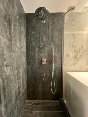 a bathroom with a shower with a black marble wall at Loft in Psirri by Liberty's Canvas in Athens
