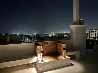a fire pit on a balcony with a view of a city at Athens Neos Kosmos penthouse, sea and city view in Athens