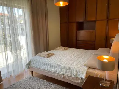 a bedroom with a bed and a large window at Athens Neos Kosmos penthouse, sea and city view in Athens