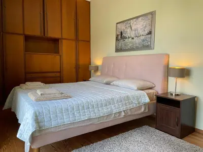 a bedroom with a bed with a pink headboard and a table at Athens Neos Kosmos penthouse, sea and city view in Athens